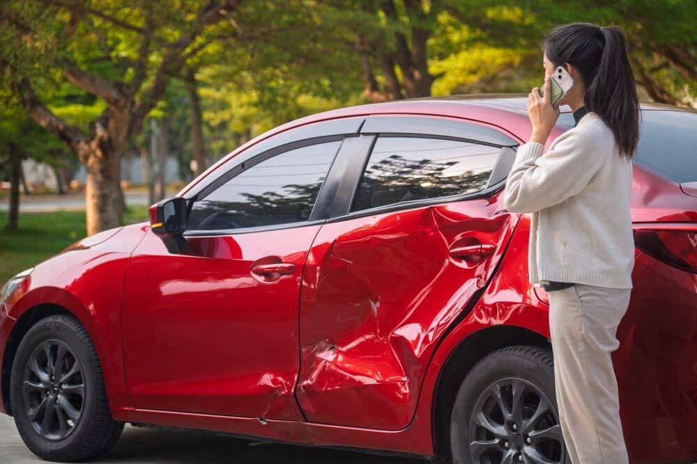 Accidente de coche. Mujer asiática joven después de un accidente de coche.