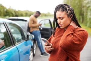 Mujer conductora implicada en un accidente de coche llamando a la compañía de seguros o al servicio de asistencia
