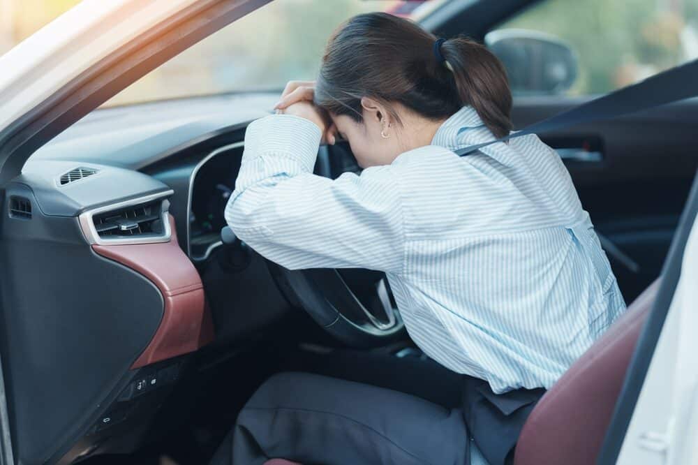 mujer sintiendo estrés y enfadada durante la conducción del coche durante mucho tiempo.