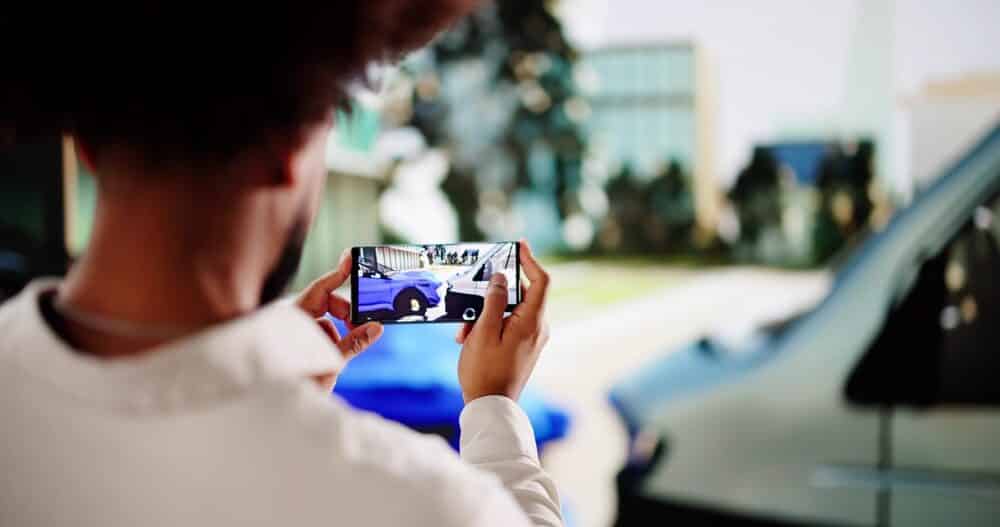 Ajustador de seguros tomando fotos de accidente de tráfico para proceso de reclamación.