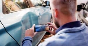 Investigador de seguros captura pruebas de las secuelas de un accidente de tráfico con un smartphone.
