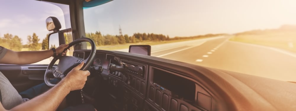 Conductor de camión sentado al volante y conduciendo un vehículo.