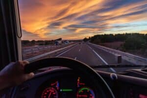 Vista desde el asiento del conductor de un camión en una autopista con vehículos en ambas direcciones.