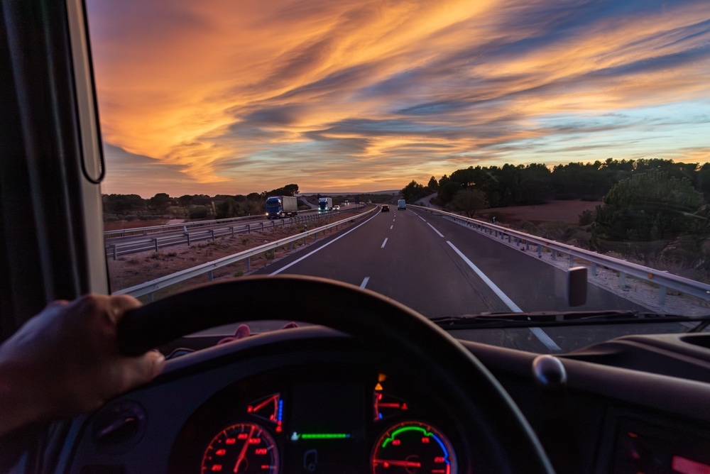 Vista desde el asiento del conductor de un camión en una autopista con vehículos en ambas direcciones.