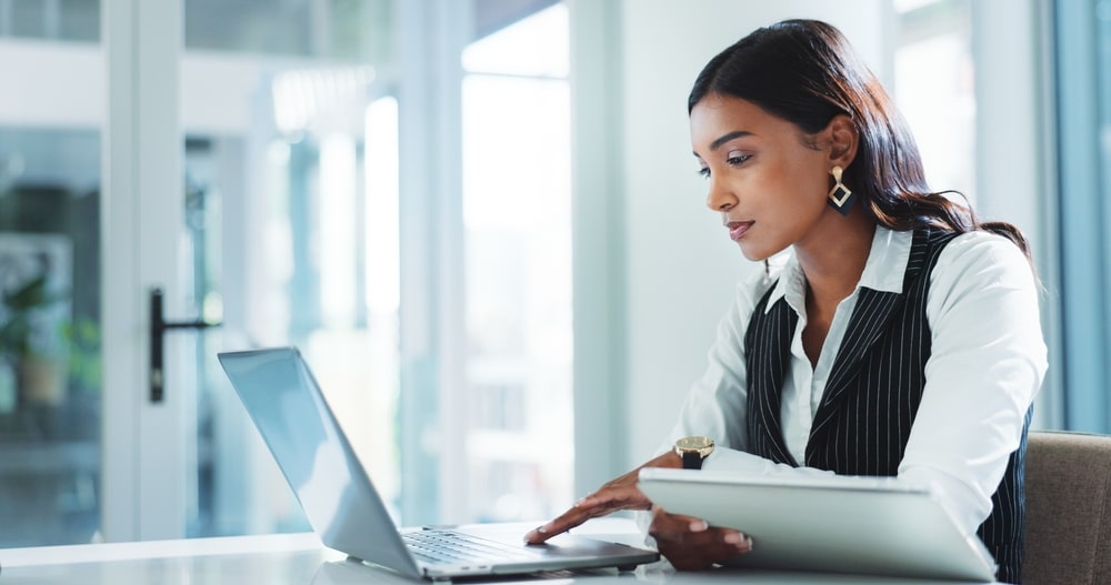 Oficina, mujer seria y de negocios en portátil para seguros, gestión de riesgos o ventas de pólizas en internet.