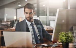 Hombre, negocios y portátil en oficina para finanzas, correo electrónico y redes para crecimiento en empresa. Corredor de seguros, ordenador y escribiendo en agencia para contacto, comentarios y consulta en línea con tecnología.