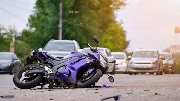 Hit by motorcycle accident scene with fallen bike and cars in Newport Beach.