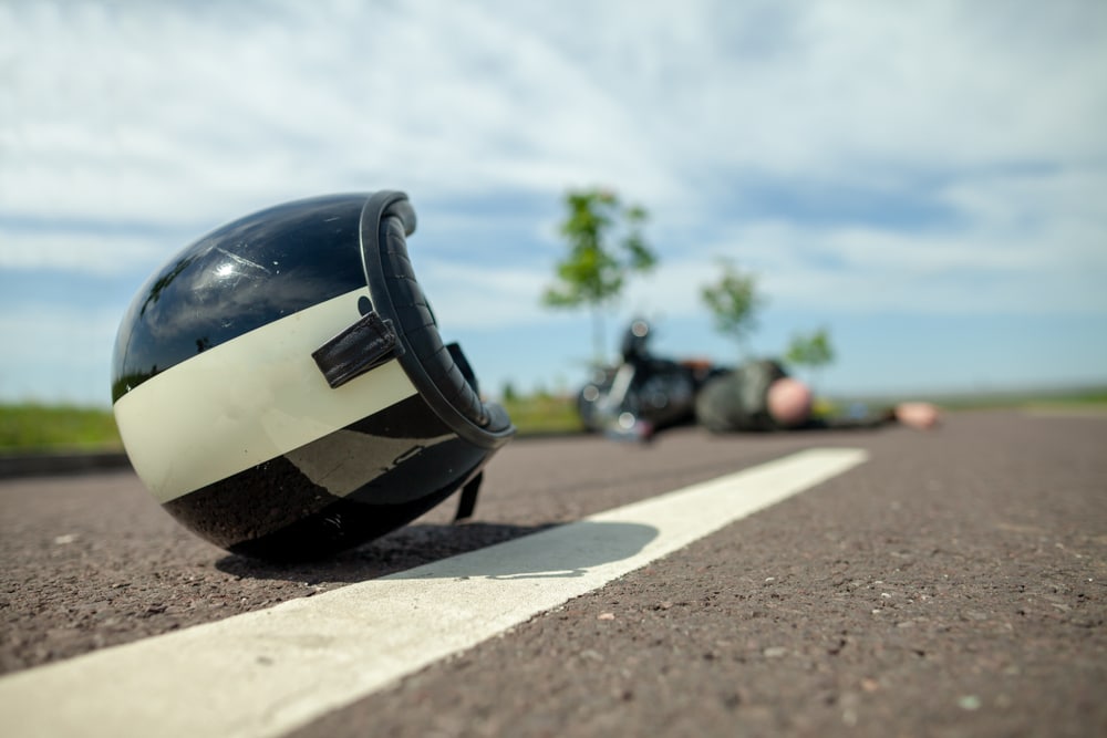 Casco de moto tirado en la carretera tras un choque, ilustrando qué no hacer después de un accidente de moto