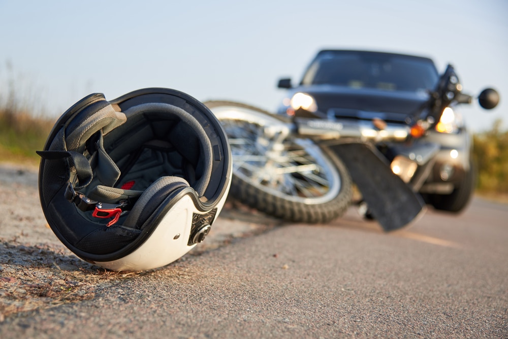 Casco de moto apoyado en el asiento de una moto aparcada, dejando al propietario preguntándose cómo demandar tras un accidente de moto.