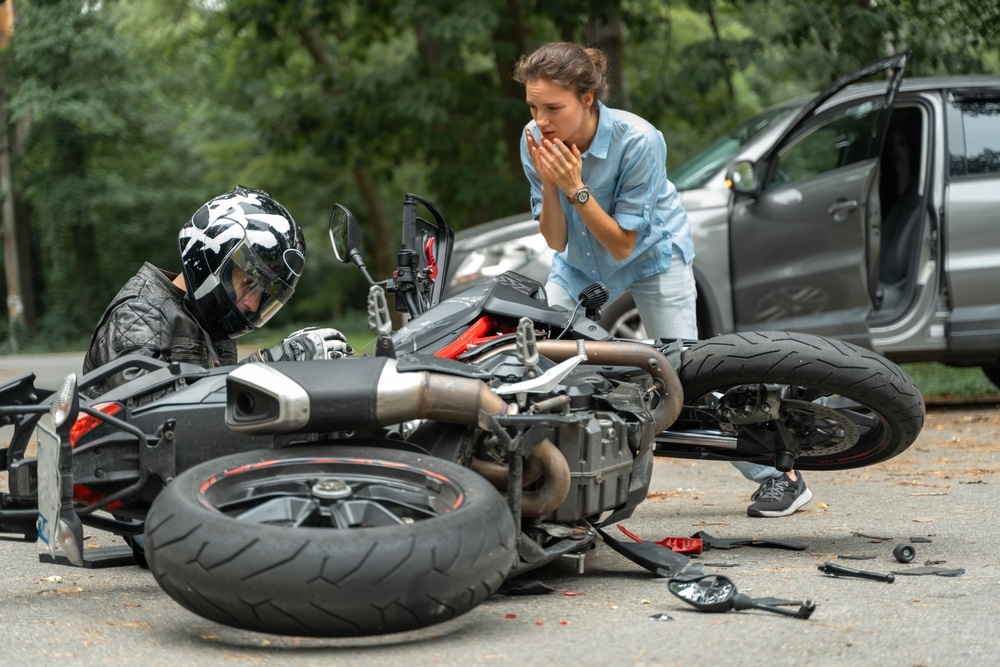 Un motociclista lidiando con una lesión después de un accidente de motocicleta que involucra a un automovilista